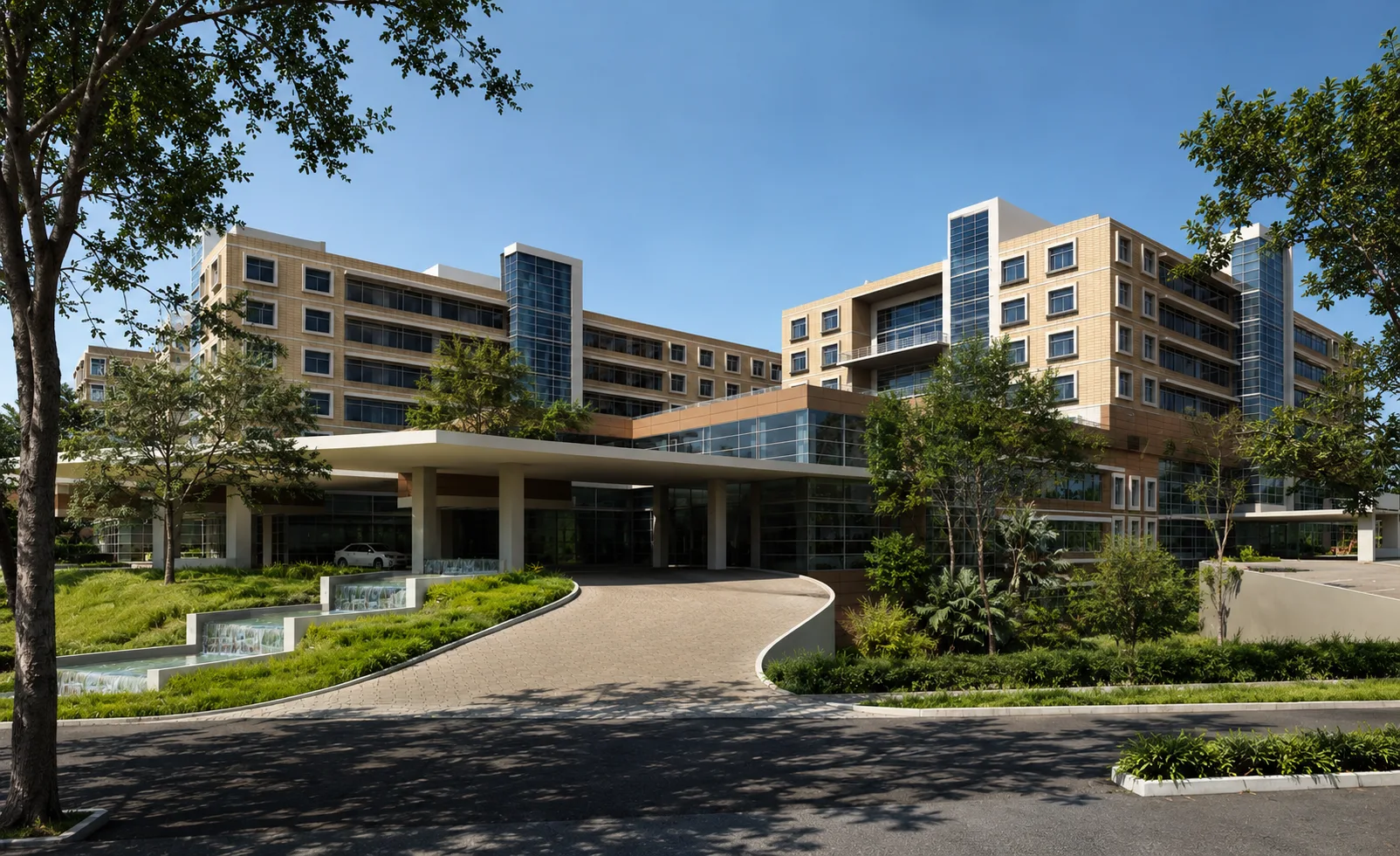 Aster DM Healthcare campus entrance with brick-clad wards and landscaped approach